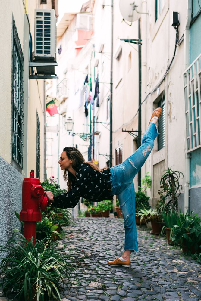 Casual woman dancing on old city street