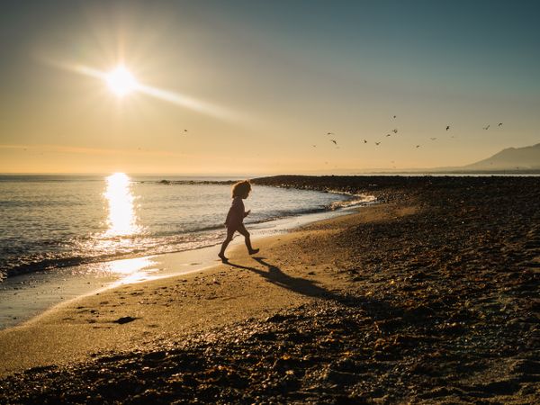 small girl walking by the beach