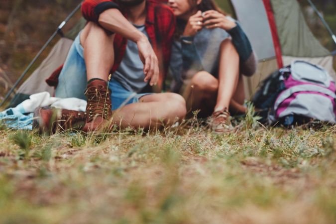 Romantic young couple sitting outside a camping tent
