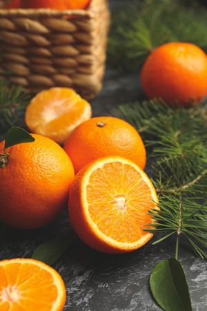 Mandarins, pine branches and basket on gray smoky background