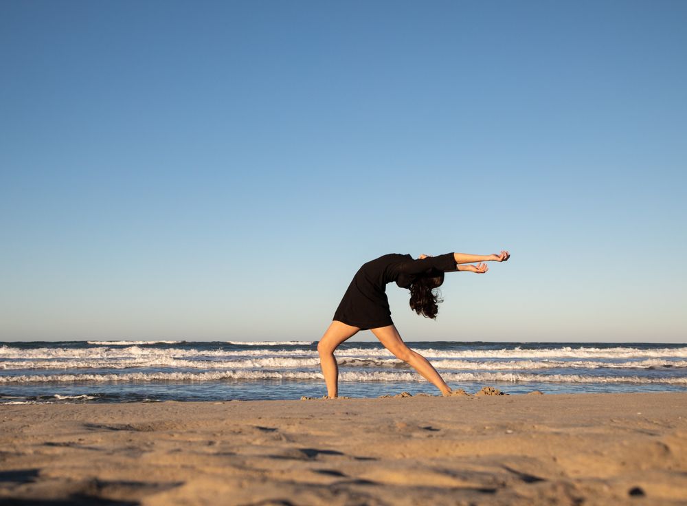 Woman with dancing near water on shore