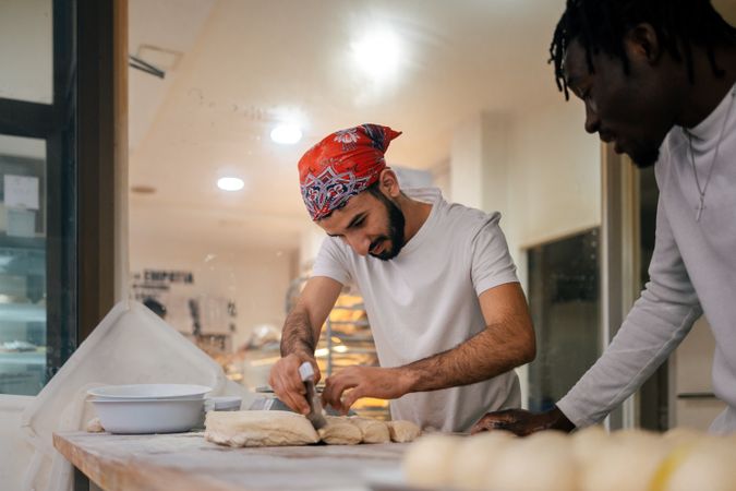 Arabic baker cutting dough with scapula