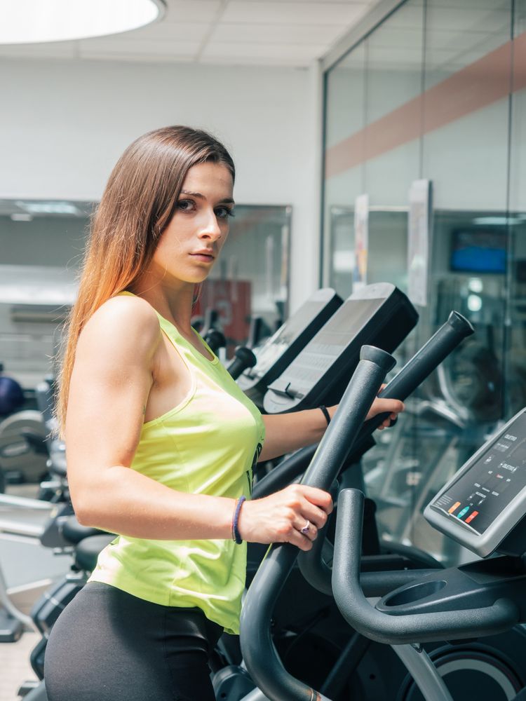 Young woman exercising on modern machine