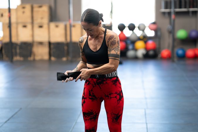 Woman putting on weight lifting belt