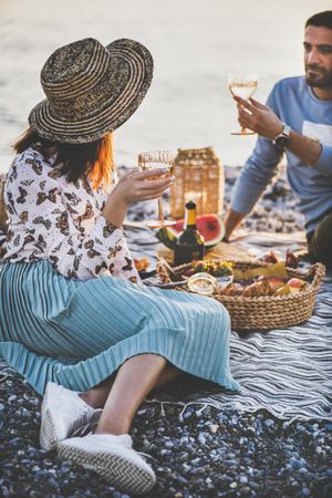 Couple talking at outdoor summer picnic with wine