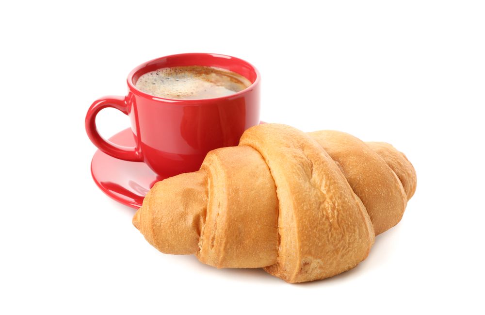 Cup of coffee and croissant isolated on plain background