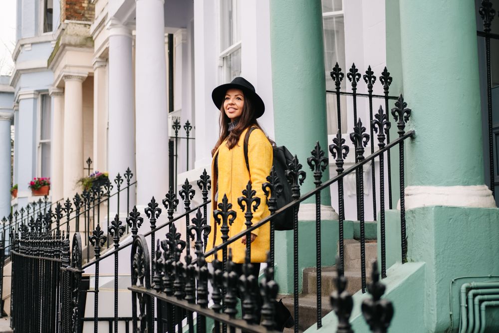Cheerful woman standing in stairs in typical london buildings