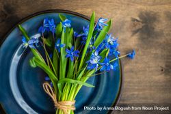 Top view of Easter table setting with lush scilla flowers on wooden table 5lVVze