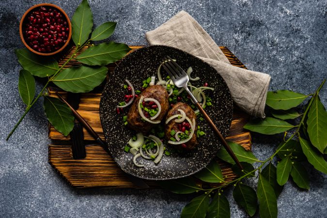 Top view of two abkhazura cutlets served on plate served with pomegranate seeds