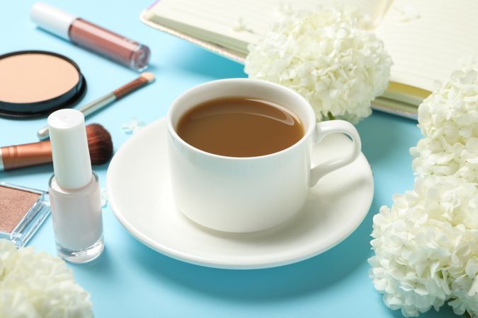 Composition with hydrangea flowers, coffee and cosmetics on blue background