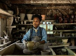 Costumed interpreter in the pottery shop at Old Sturbridge Village, Sturbridge, Massachusetts