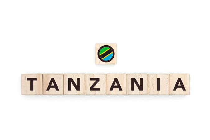 Wooden blocks bearing the name and flag of Tanzania. Tanzanian and South African Culture, national identity, travel, and geography in a copy space design.