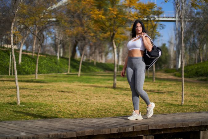 Slim woman doing stretching exercise in park