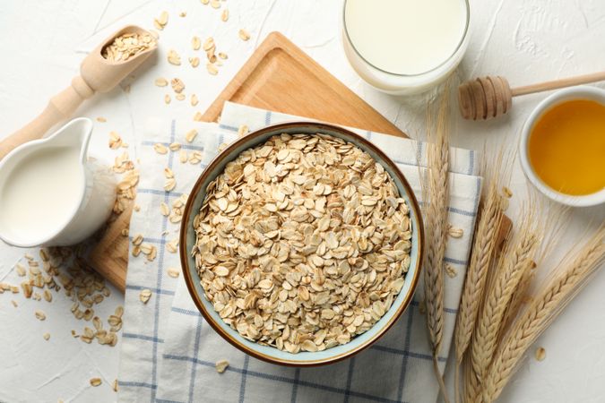 Composition with oatmeal flakes on plain background, top view. Cooking breakfast