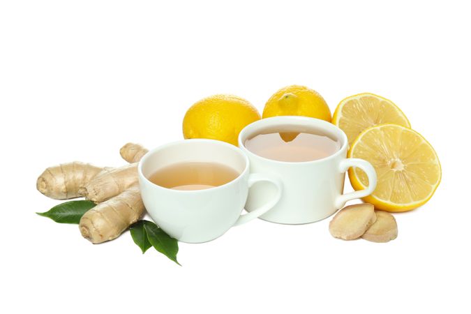 Cups of tea, ginger and lemon, isolated on plain background