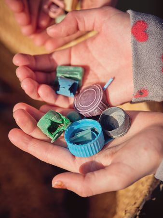 Anonymous children hands with pieces of plastic