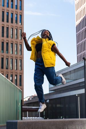 Excited female jumping on city street