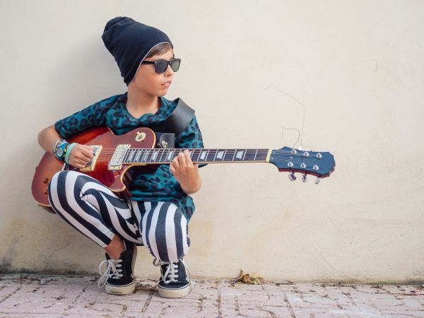 Energetic kid holding guitar