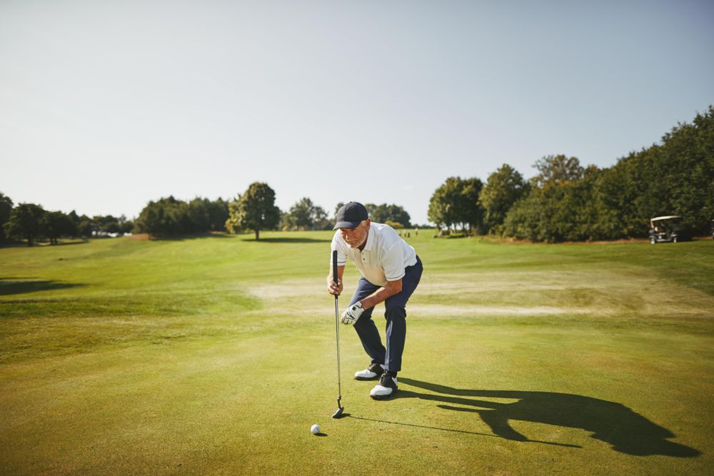 Man preparing to put on golf course