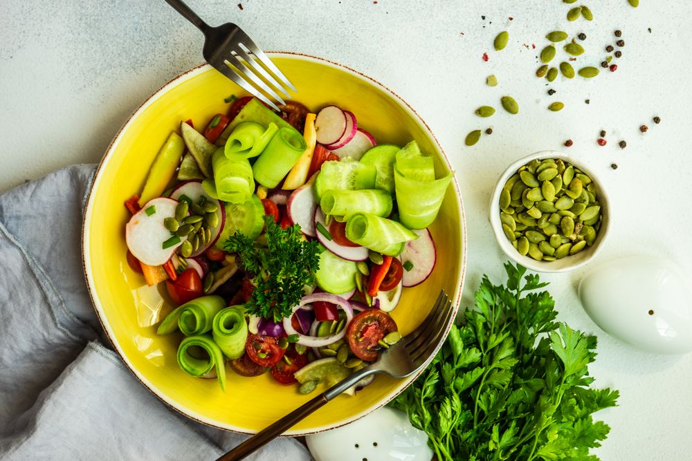 Raw salad with chopped vegetables served with nuts and garnish