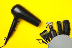 Composition with hairdresser accessories on yellow background, top view