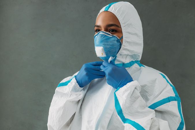 Black woman in hazmat suit, protective gloves and face mask
