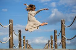 Woman with textile posing in air on footbridge