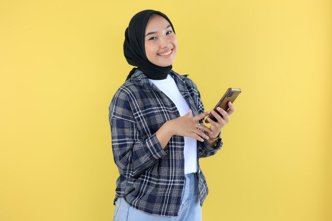 Asian Young Woman Cheerful using a Smartphone