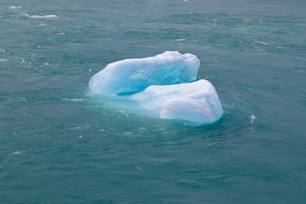 Large blue iceberg floats in the ocean