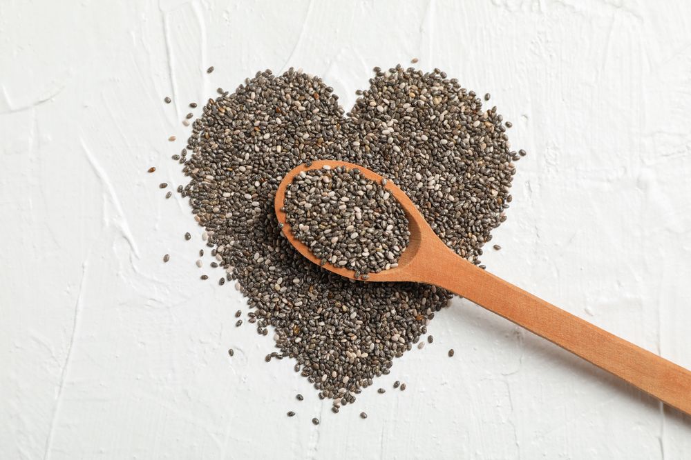 Heart layout of chia and wood spoon on neutral background, space for text