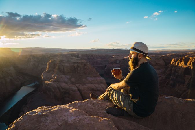 Man drinking near canyon