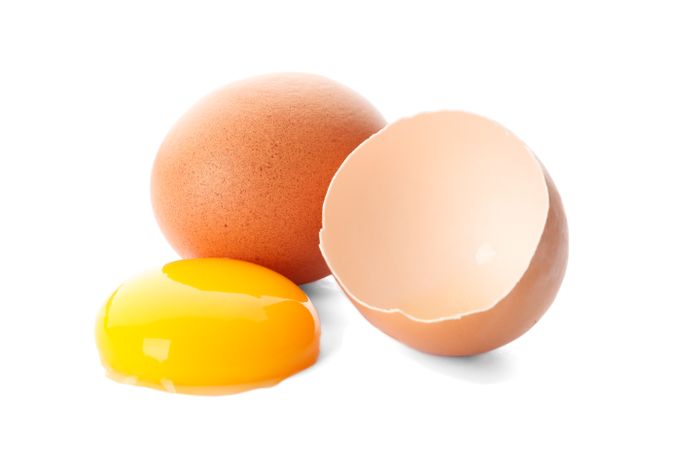 Chicken eggs and half yolk isolated on blank background