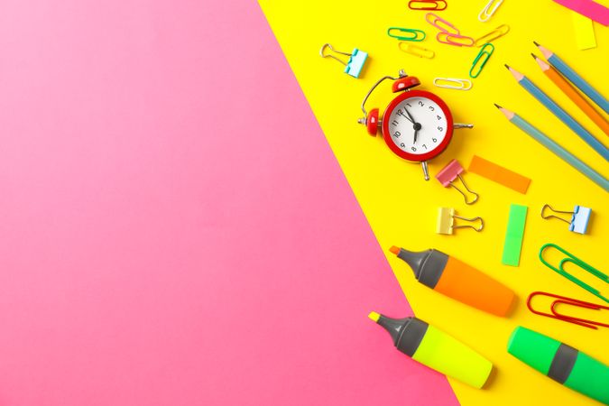 Flat lay composition with school supplies on two tone background, space for text