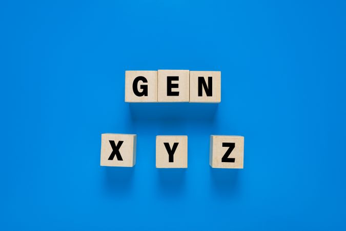 wooden blocks with gen x, y, z symbol. isolated on blue background. concept of generation gap
