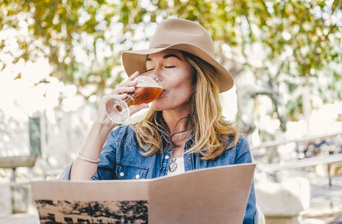 Woman sitting outside cafe drinking beer