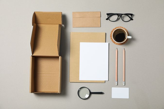 Mockup. Corporate stationery, glasses and magnifier on grey background. Flat lay