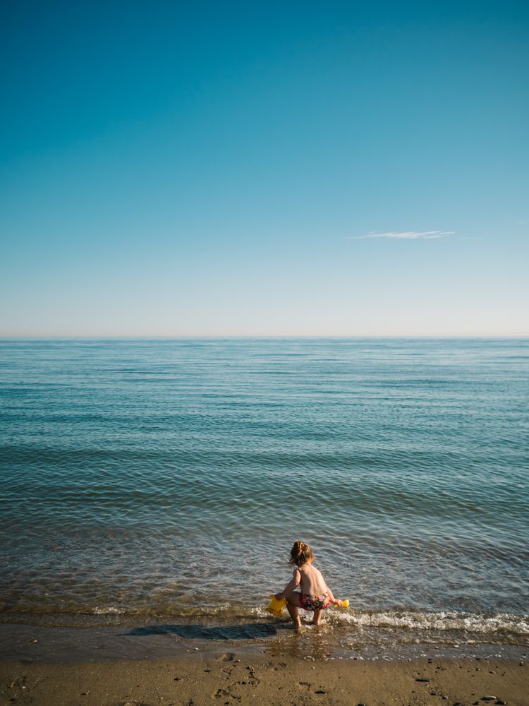 Girl playing with little stones on beach