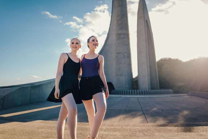 Two female ballet dancers standing together outdoors