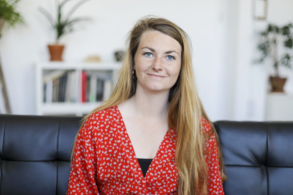 Portrait of content young woman sitting on sofa