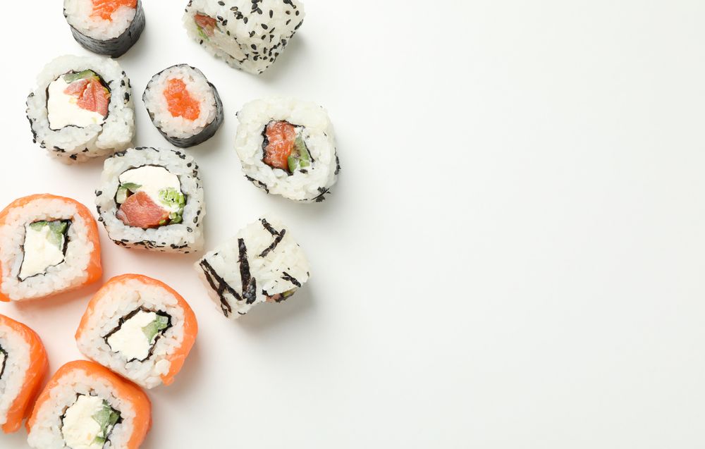 Delicious sushi rolls on plain background, top view. Japanese food