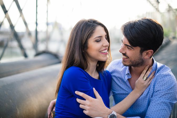 Amorous couple bonding on railway under bridge