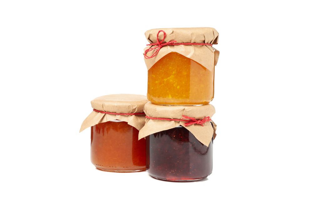 Glass jars with jam isolated on blank background