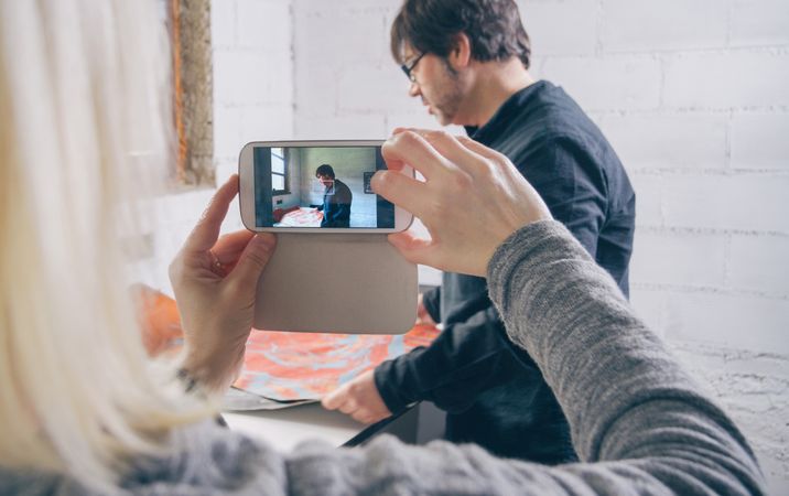 Woman hands taking photo to painter artist working