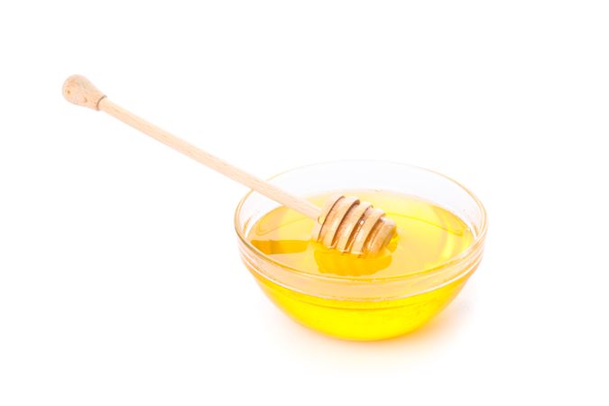 Dipper and honey in glass bowl isolated on blank background