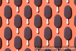 Chocolate popsicle in neat order on orange background 0Vvwj0