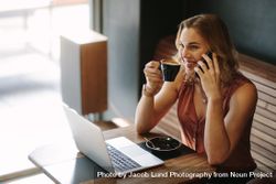Woman doing her work sitting at a coffee shop while drinking a cup of coffee 5p2Leb