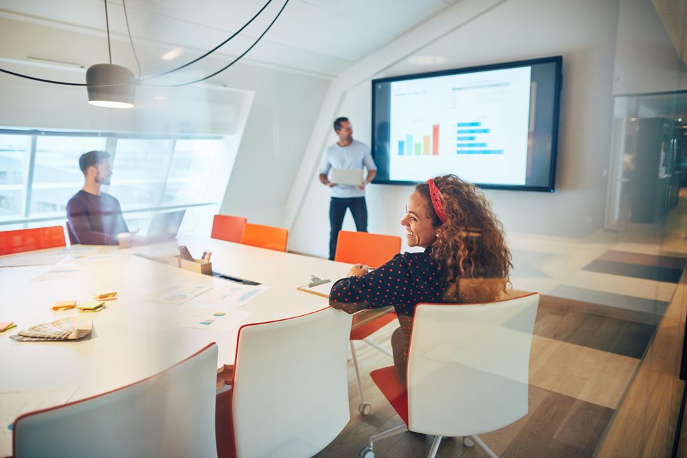 Group of people enjoying a presentation in an open modern office