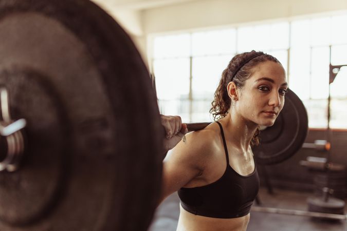Fit woman lifting a barbell at the cross fit gym