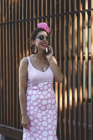 Erratic woman in flamenco dress talking on phone at street