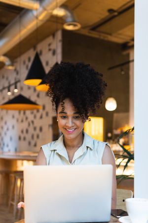 Smiling Black woman browsing laptop